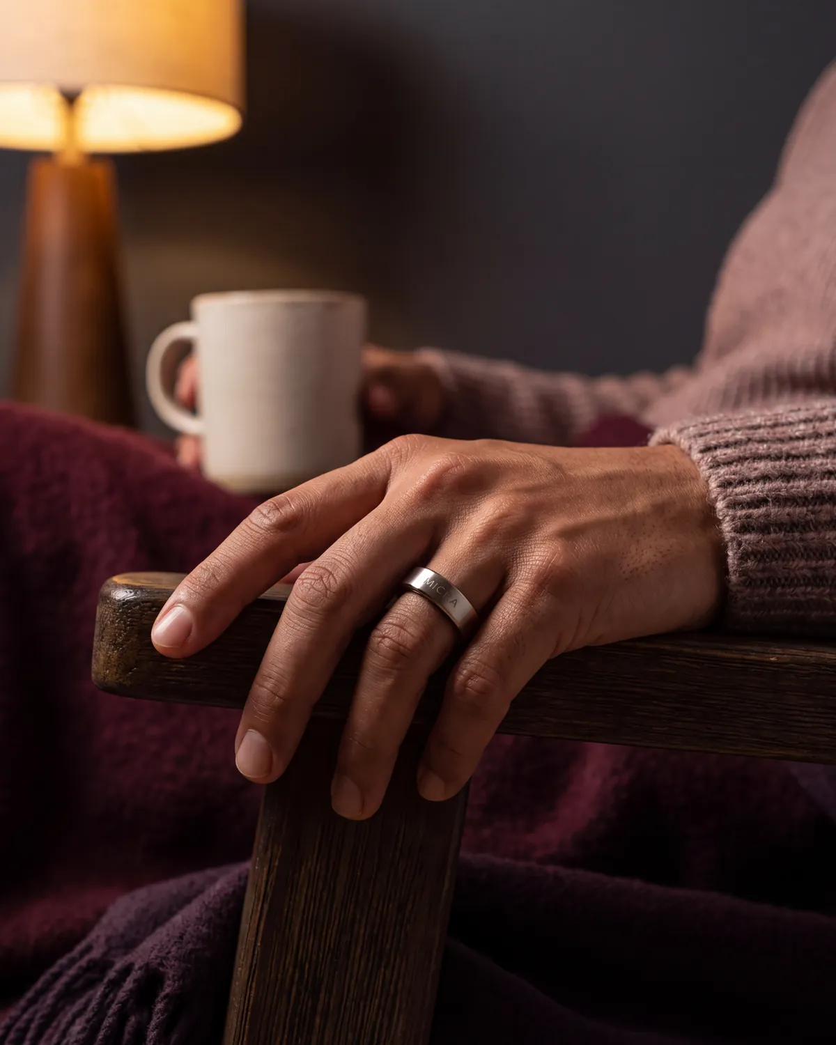 Detalle de una mano relajada con anillo inteligente sobre un descansabrazos