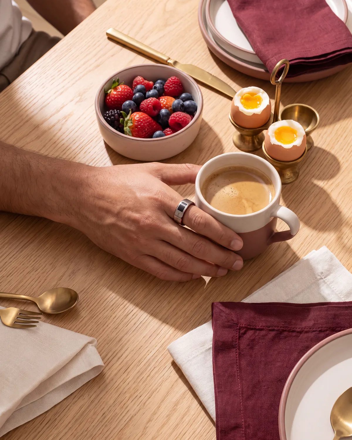 Mesa con desayuno sencillo y una mano con anillo inteligente