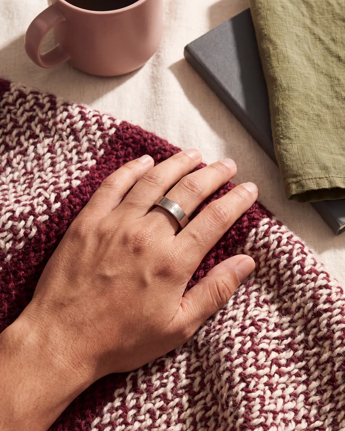 Detalle de la mano en reposo sobre el regazo con un anillo inteligente