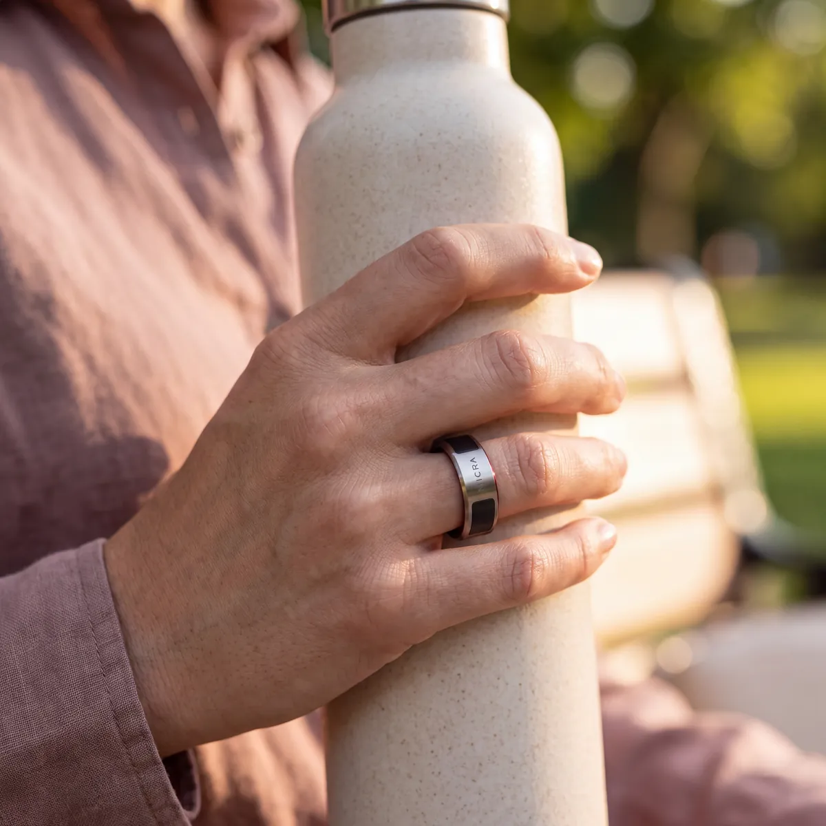 Mano con anillo inteligente sujetando una botella de agua tras caminar