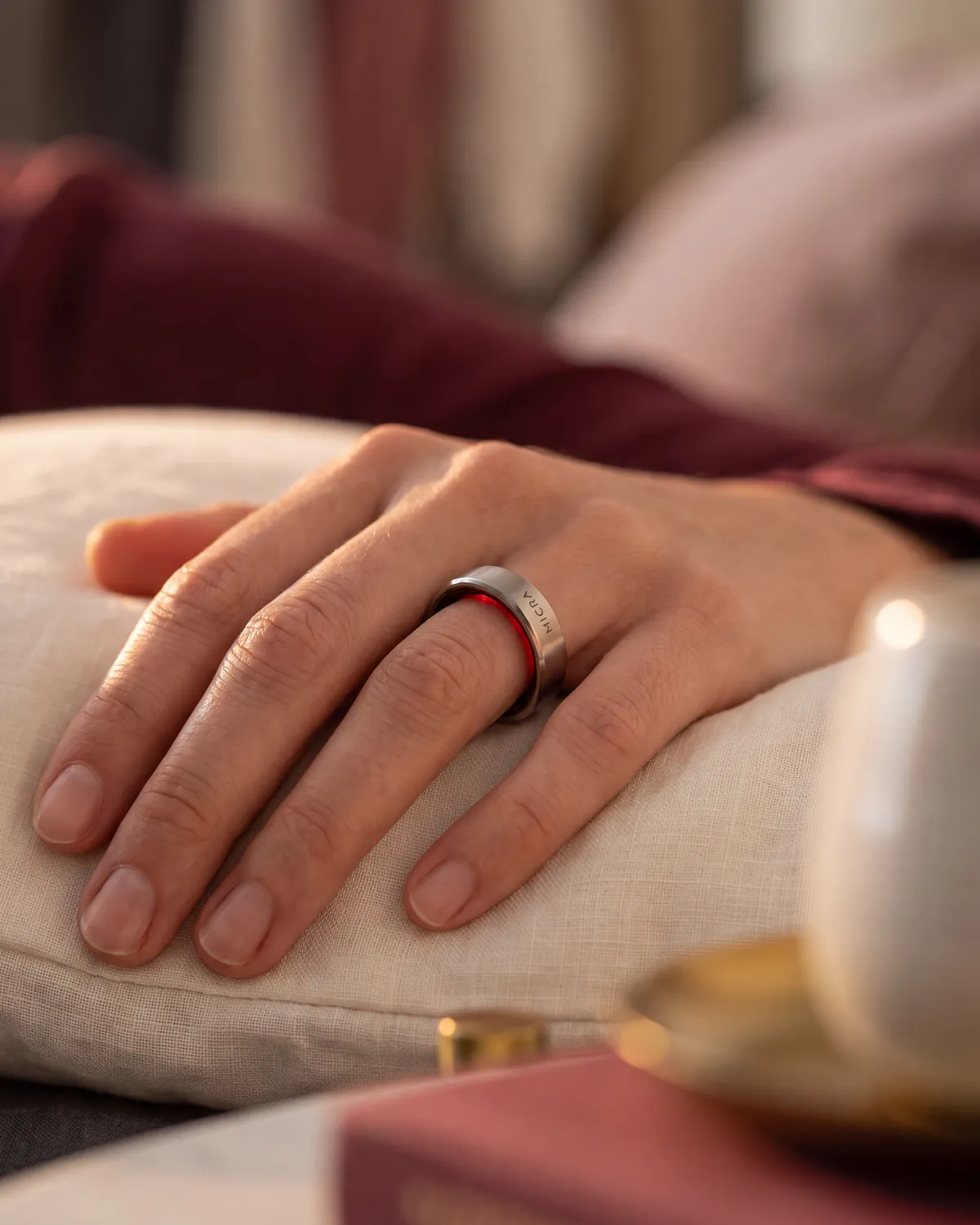 Mano con anillo inteligente sobre una almohada de lino